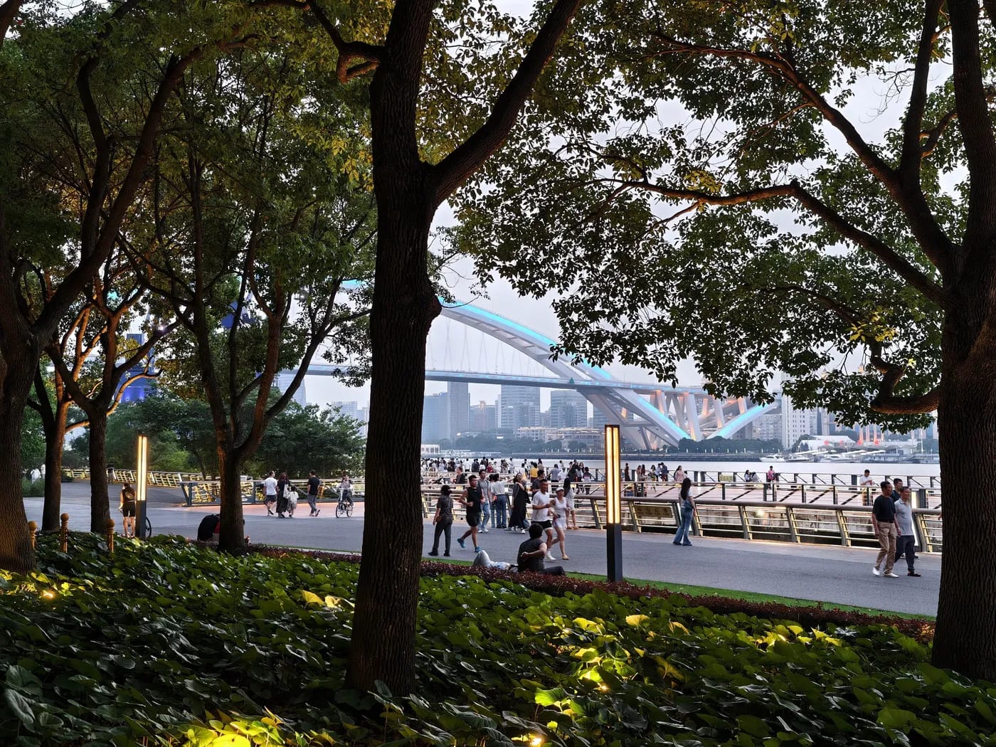 People walking and relaxing beside the river at Shanghai Expo Park