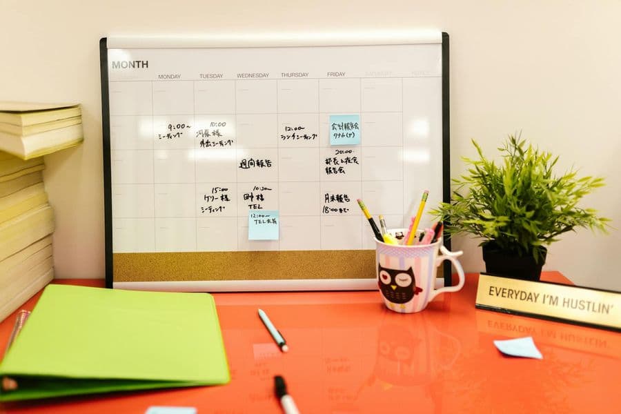 Desk calendar, sticky notes, and stationery flat lay representing planning and coordination (Pexels stock by RDNE Stock project).