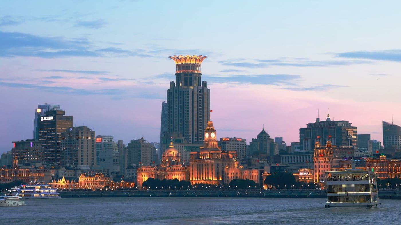 Panoramic Shanghai Bund and Pudong skyline at dusk, with reflections on the Huangpu River (Pexels stock by Olivia Cai).