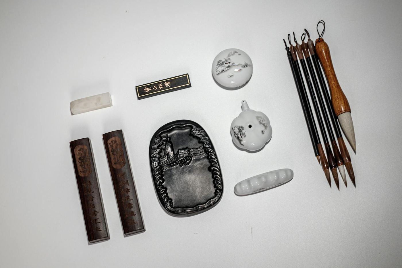 Antique Chinese ink stone, brushes, and ink sticks on a wooden desk — used as visual context for Chinese-paperwork themes (Pexels stock by Feng Zou).